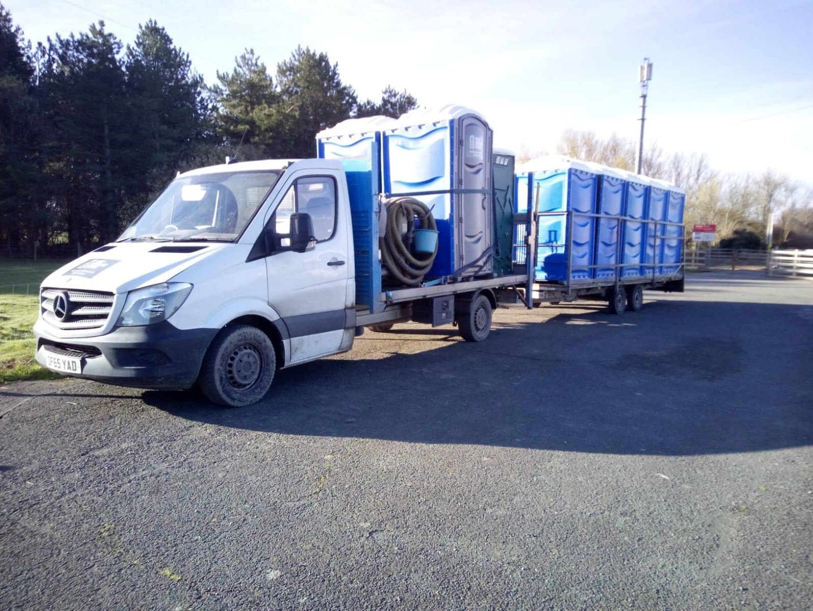 A truck carrying a row of portable toilets across mid wales