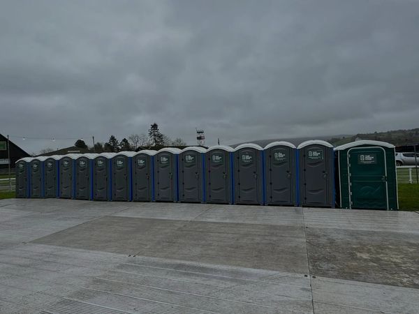 A row of 15 portable toilets at an event in mid wales