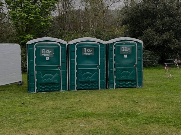 a row of three handicapped portable toilets at a sports event in mid wales