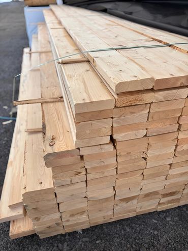 Stack of light-colored wooden planks with metal straps securing them