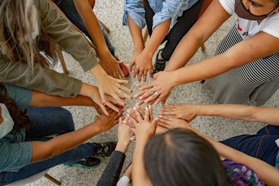 Diverse group with hands joined together in unity.