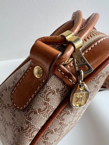 Close-up of a luxury handbag with leather and gold accents.