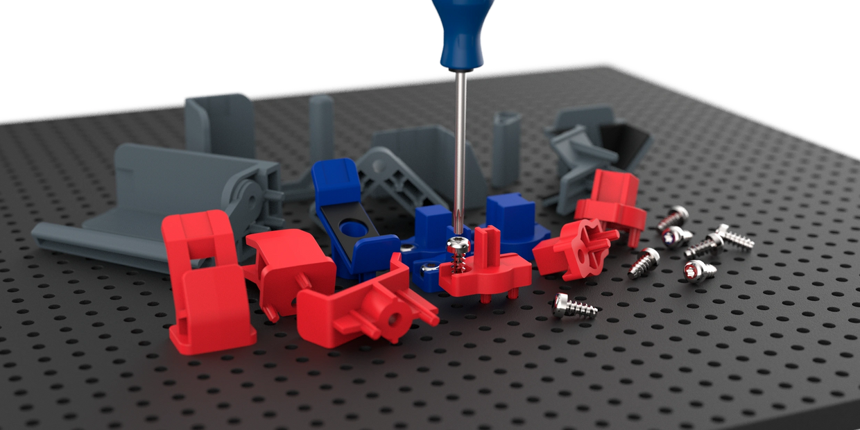 toolgrid holders loose on a toolgrid board, with one piece being screwed in with a screwdriver