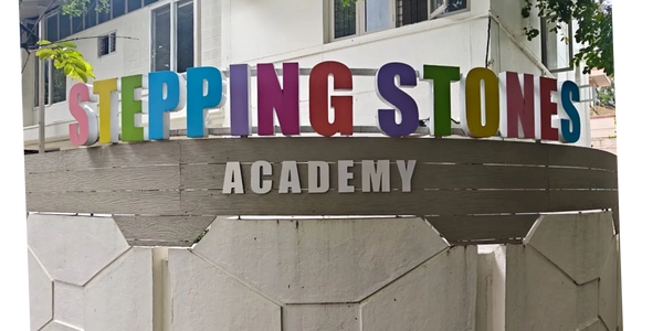 Colorful signboard of Stepping Stones Academy on a building.