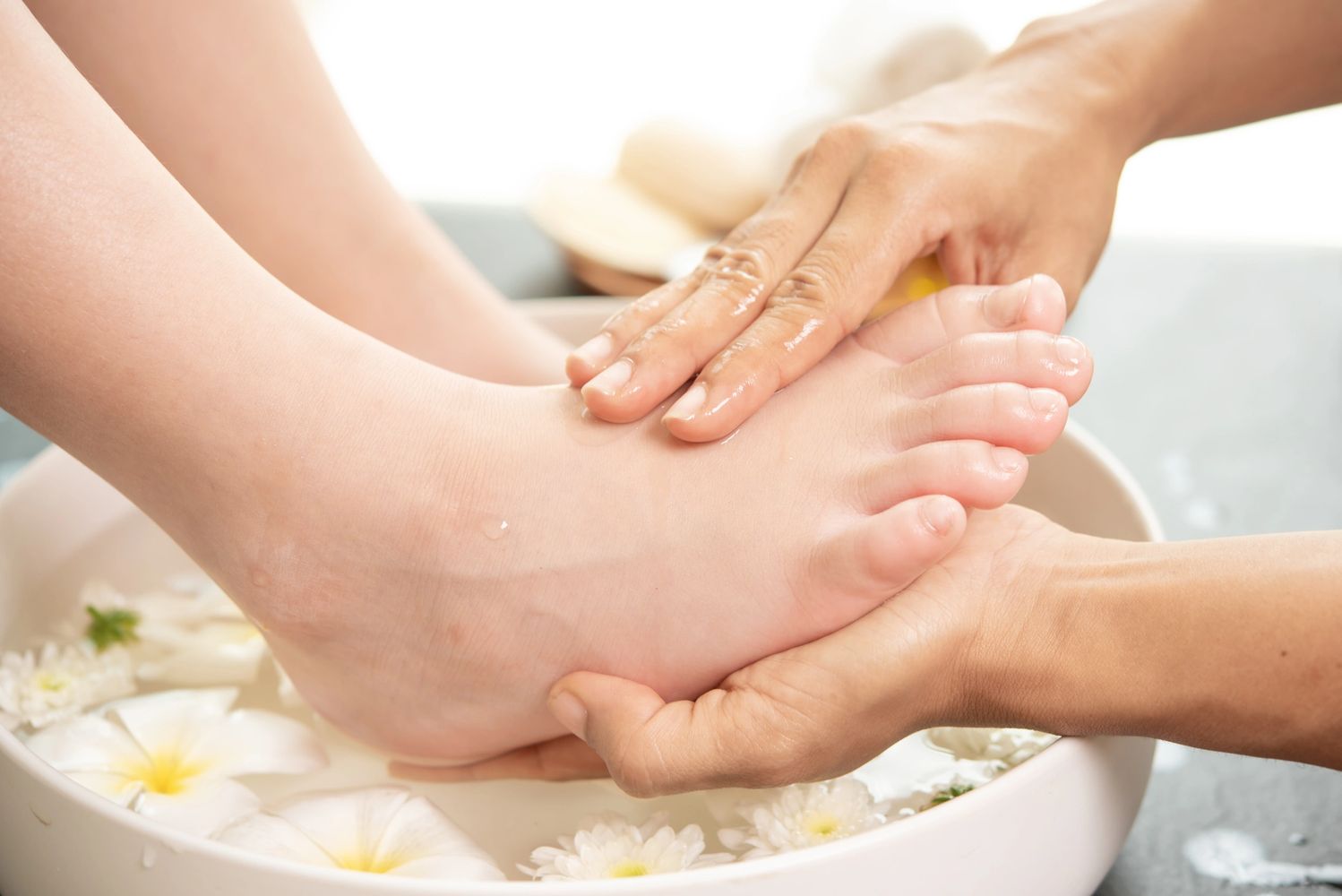 A foot massage with floral water therapy in a spa setting.