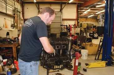 Man working on engine in a garage.