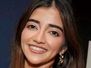 Close-up portrait of a smiling woman with earrings.