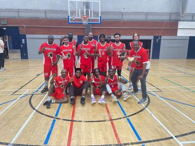 Basketball team posing on indoor court.