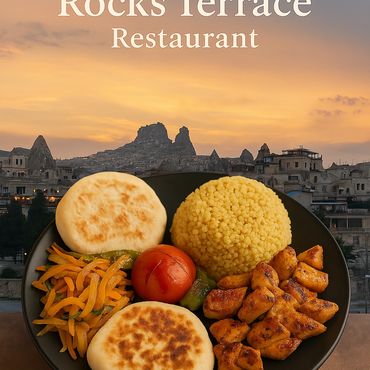 ギョレメの夕焼けを背景にした Rocks Terrace Restaurant のトルコ式前菜と温かい料理のプレート。