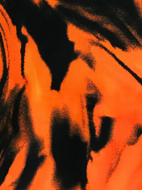An orange storm print on black fabric.