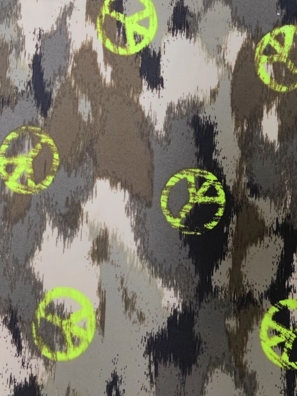 Fluorescent peace signs printed on camouflage fabric.