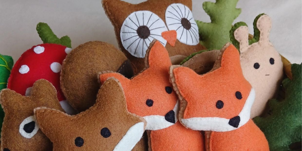 Handmade felt animal toys including foxes, an owl, and a snail.