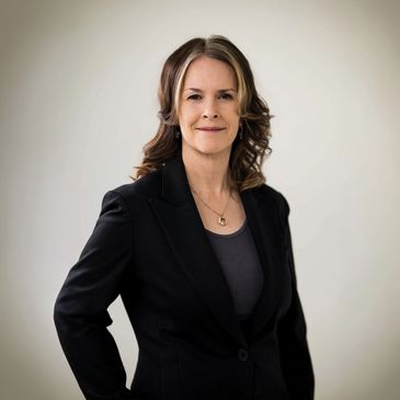 Confident woman in a black blazer posing.