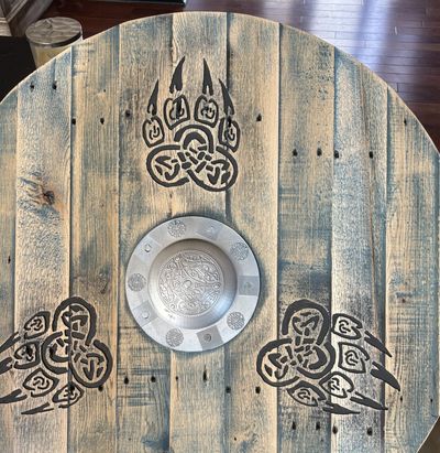 Rustic wooden table with bear claw art and a decorative metal plate.