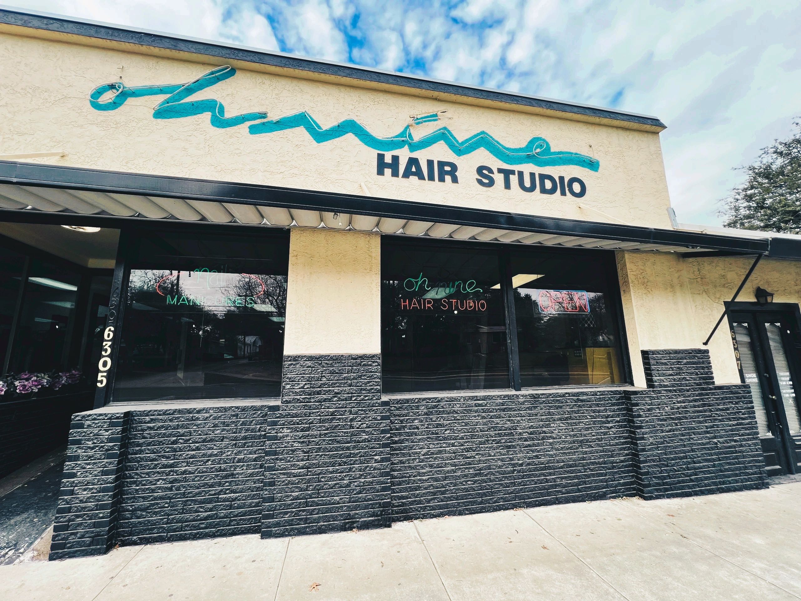 beige building with black bricks with sign that reads Oh Nine Hair Stuido.