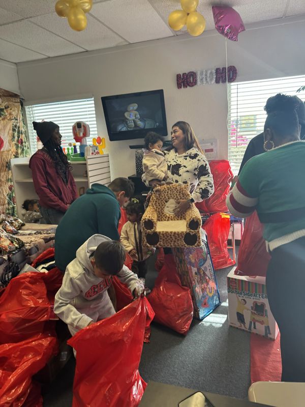 Group packing gifts in a decorated room.
