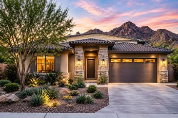 Modern house with desert landscaping at sunset.