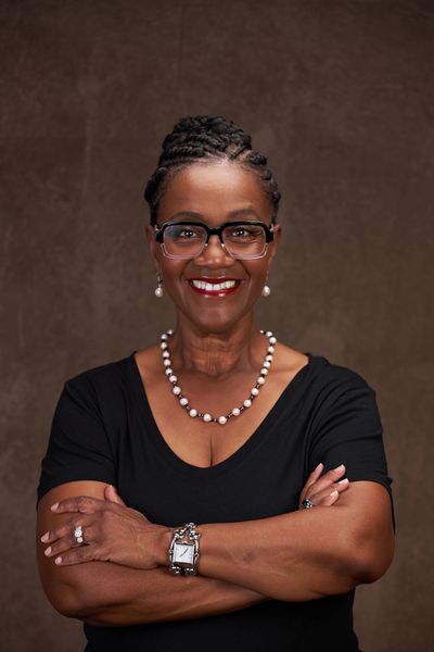 T E Anderson, a Black woman in a black dress wearing eyeglasses