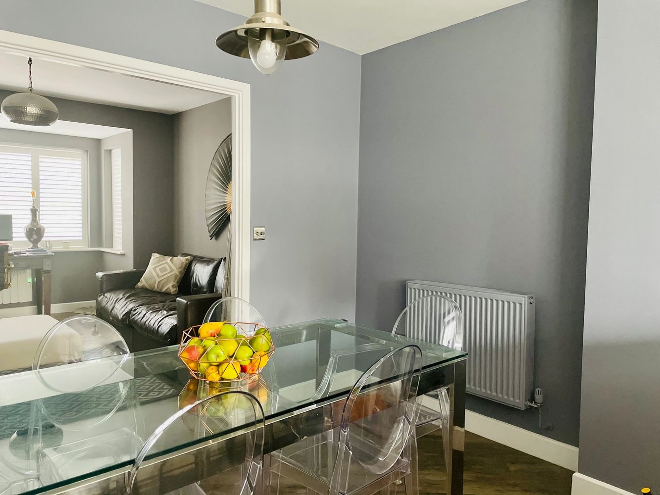 Modern dining area with glass table and transparent chairs.