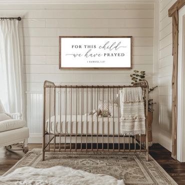 Cozy neutral-toned nursery with a crib and inspirational wall art.