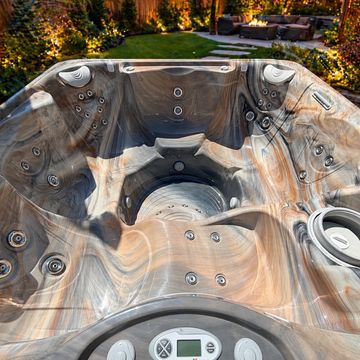Empty luxurious hot tub with multiple jets in a backyard setting.