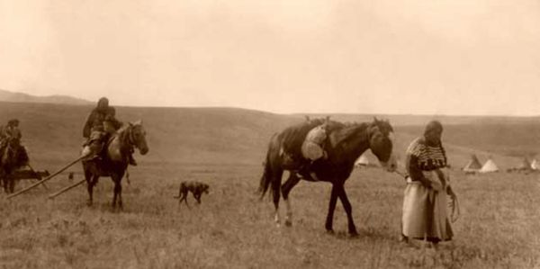Historical image of Native Americans with horses and tepees.