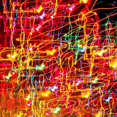 Colorful abstract light trails on a red background.