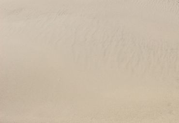 Close-up of smooth sand with subtle ripple patterns.