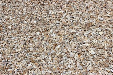 A close-up view of a surface covered with small, mixed-color pebbles.
