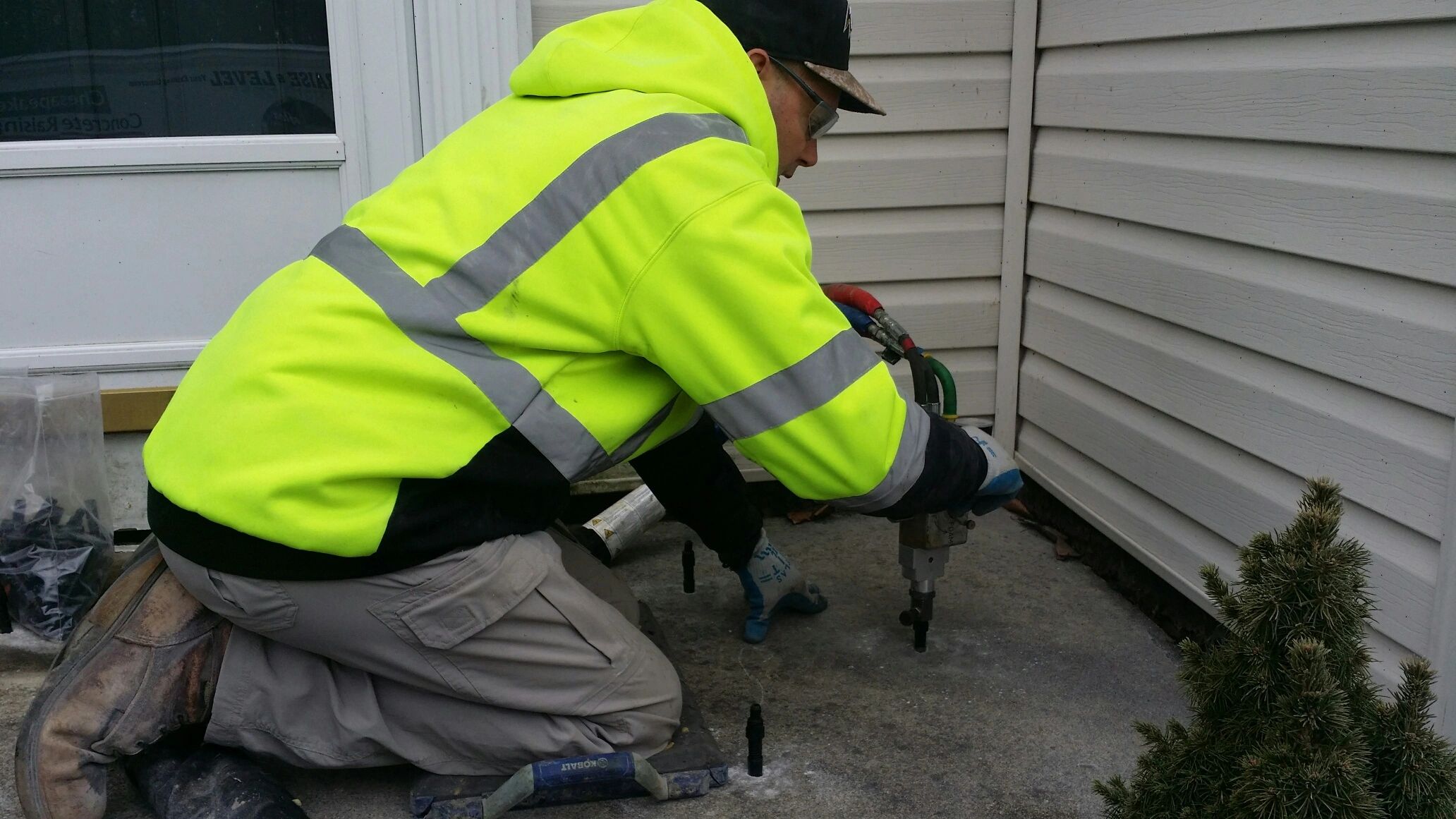 Concrete raising in action on a severely sunken porch stoop