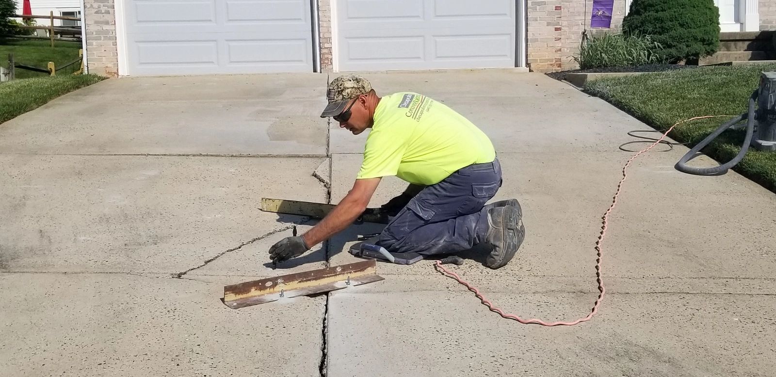 Inserting ports for injecting foam using a rubber mallet on a driveway
