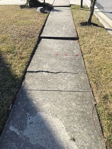 Example of a sunken and cracked concrete sidewalk
