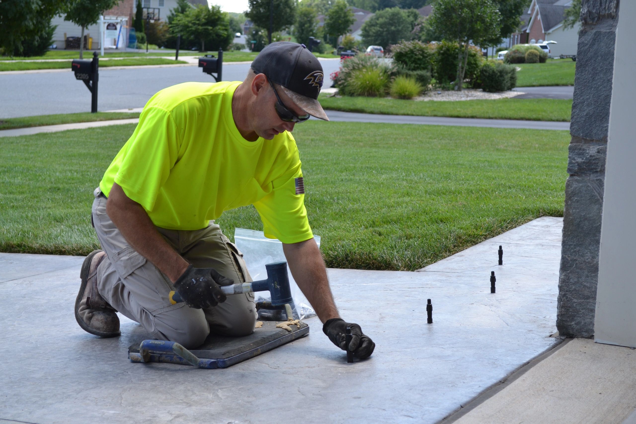 Inserting ports in a driveway using a rubber mallet for injecting foam