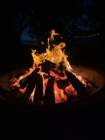 A glowing campfire burning bright against the night sky.