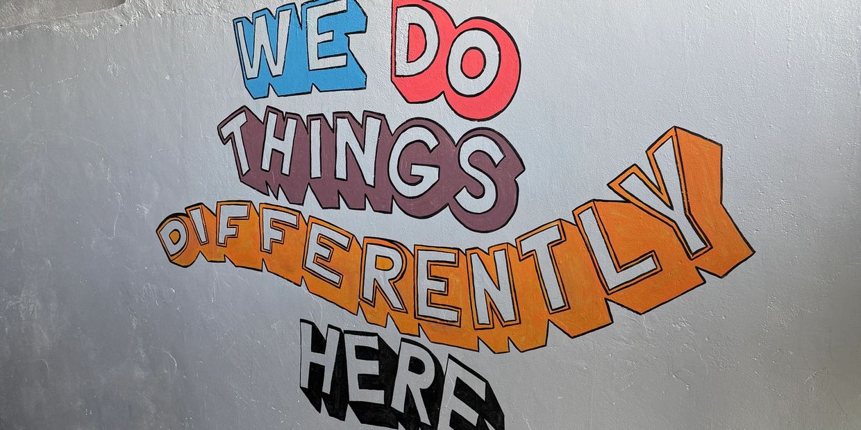 Mural on school wall that says "We Do Things Differently Here"
