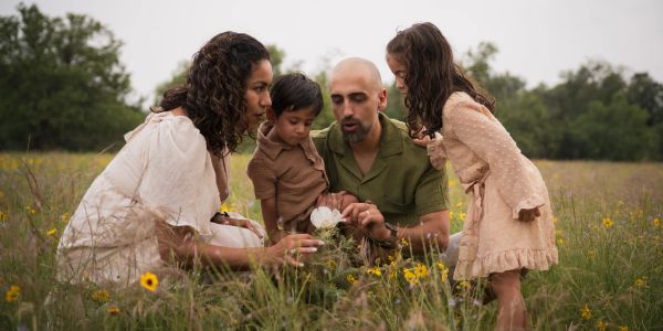 Family exploring flowers in a meadow.