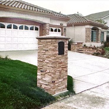 Suburban house with stone mailbox and driveway.