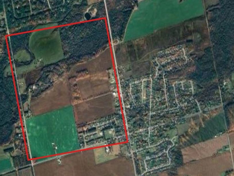 Aerial view of farmland and residential area with a red boundary.