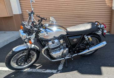 Classic silver and black motorcycle parked outside.