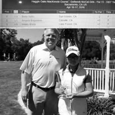 Two golfers posing with a trophy on a sunny day at a golf course.