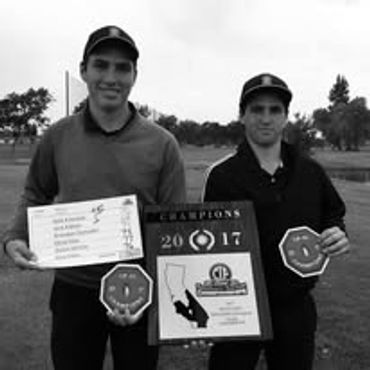 Two men holding golf championship awards.