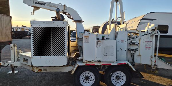 White Bandit wood chipper trailer with dual wheels parked outdoors.