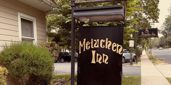 Outisde photo of the black Metuchen Inn sign
