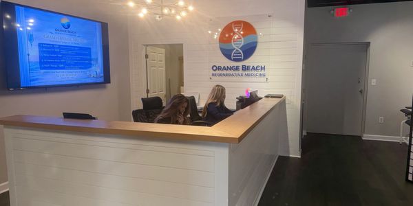 Reception area of Orange Beach Regenerative Medicine with two staff members at the desk.