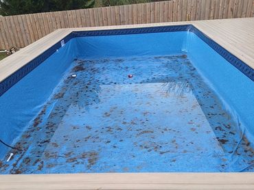 Above-ground pool liner with debris before liner wash cleanout in Pensacola, FL