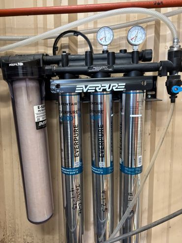 Industrial Everpure water filtration system with gauges and prefilter.