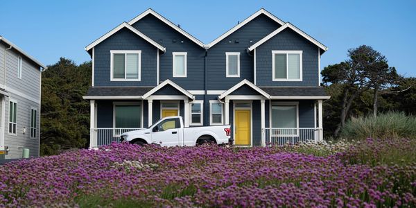 Blue House, with yellow doors in a field of flowers