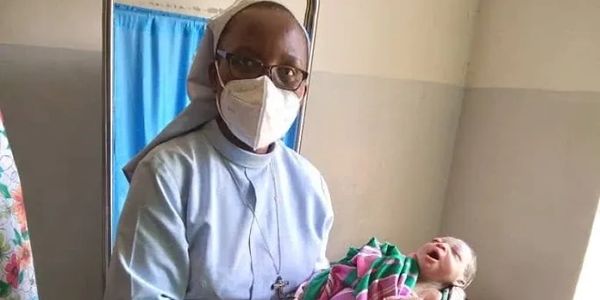 Dr. Sr. Priscilla Bunsingye, holding a newborn infant she delivered.