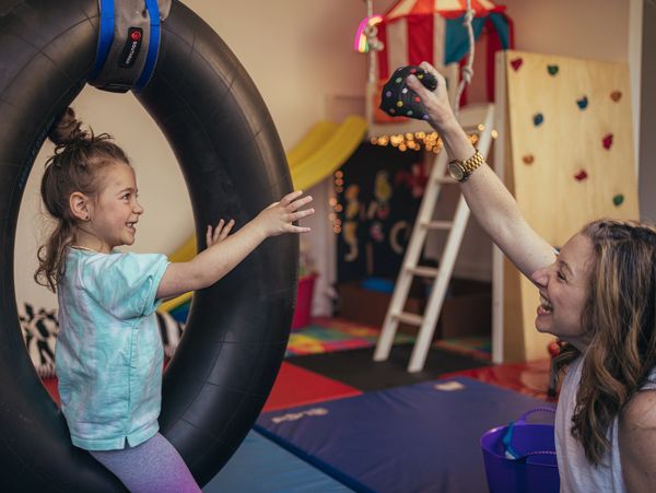 A little girl playing on a black color tire image