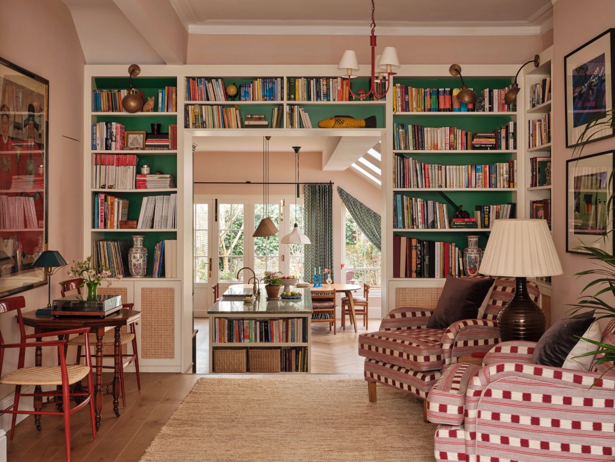 Cozy living room with bookshelves and patterned armchairs.